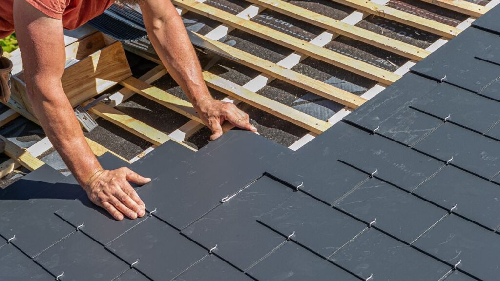 Erkende dakwerker plaats kunstleien op een hellende dakconstructie 