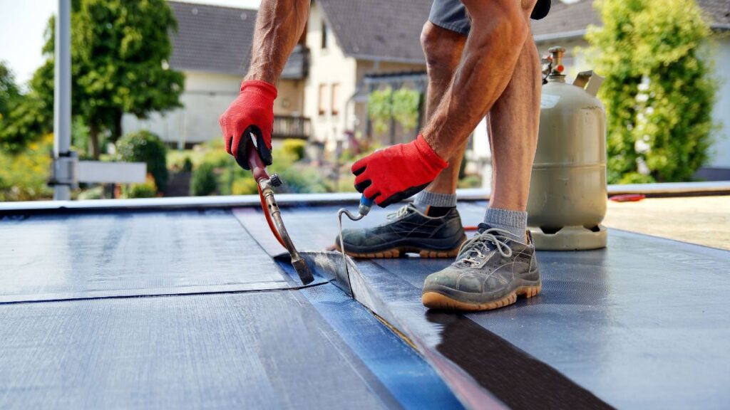 Dakspecialist gebruikt kwalitatieve gereedschappen om roofing correct op plat dak te monteren 
