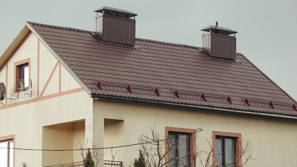 Beige huis met een zadeldak bestaande uit donkerbruine dakpannen 