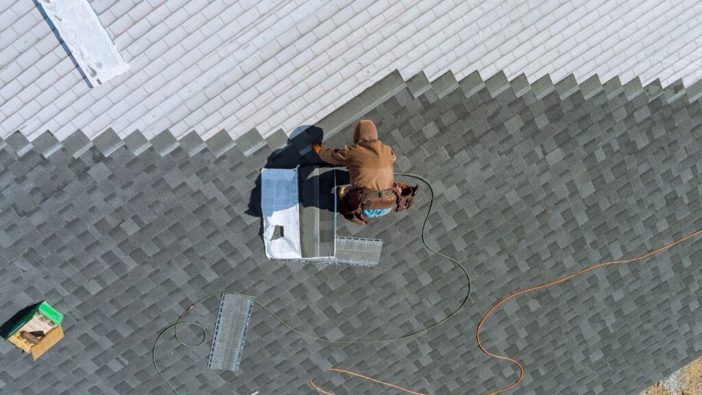 Dakwerker bevestigt shingles met de juiste gereedschappen 