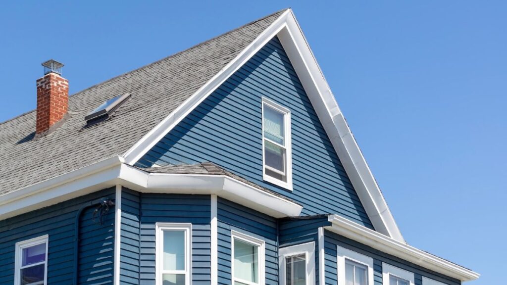 Blauw huis met een gevelkap bestaande uit zwarte leien 